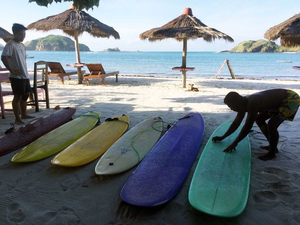 we wave surf camp is waxing up to surf in tanjung aan beach