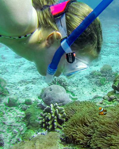 Girl snorkeling with nemo fish